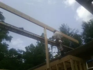 Carpenter setting a ridge beam over a new addition frame — Ice Dam Removal by Roofing Brothers in East Hartford