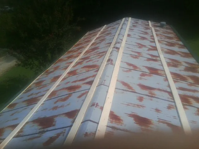 Rusted metal roof panels with new wood purlins before replacement — Storm Damage Roof Repair in East Hartford by Roofing Brothers