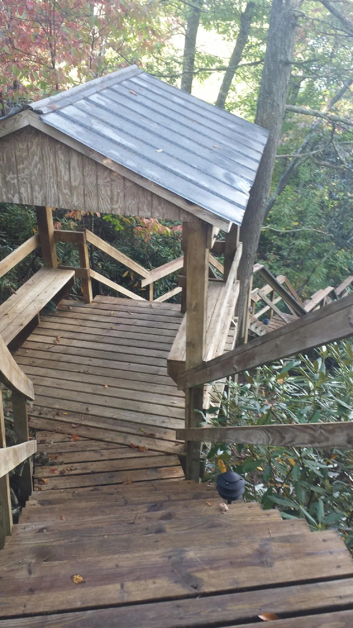 Metal roofed shelter over wooden steps on a wooded walkway — Skylight Repair & Installation work by our crew in East Hartford