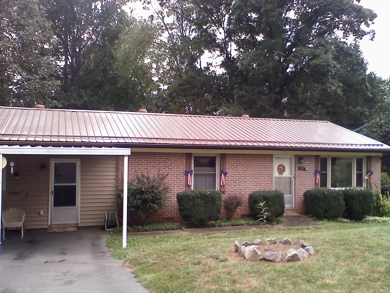 Bronze metal roof and carport on a brick ranch home — Roof Repair work by our crew in East Hartford